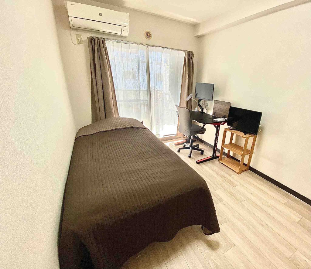 A bedroom with a big bed and a desk setup