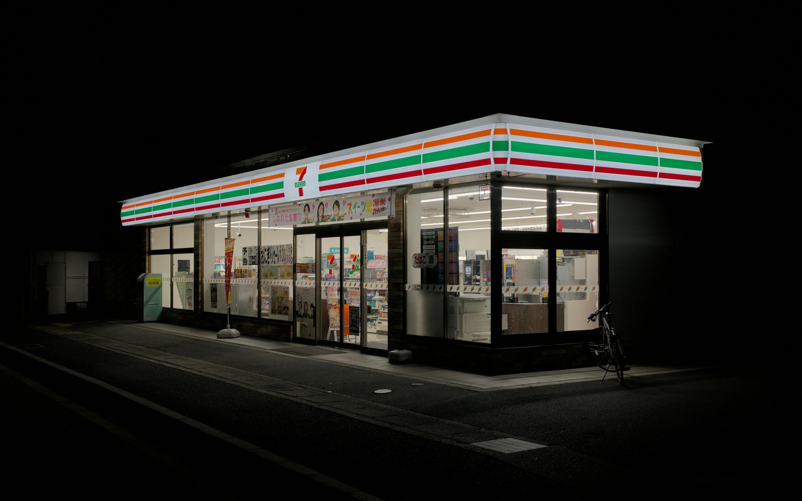A brightly lit convenience store in Kyoto, Japan, at night.